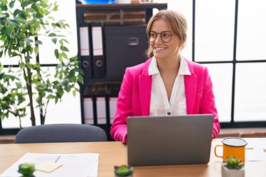 Young blonde girl business worker using laptop working at office