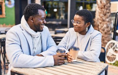 Kadın ve erkek kahve içiyor kahve dükkanının terasında oturuyor.