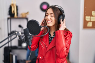 Genç, güzel, İspanyol bir müzisyen müzik stüdyosunda kendine güvenen bir şarkı söylüyor.
