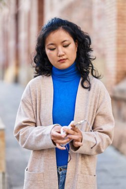 Genç Çinli kadın bardakları temizlerken ciddi bir ifade takınıyor.