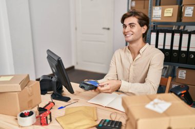 Young caucasian man ecommerce business worker using data phone and credit card at office