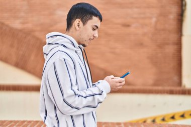 Young man using smartphone at street