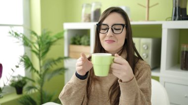 Güzel İspanyol kadın yemek masasında kahve içiyor.
