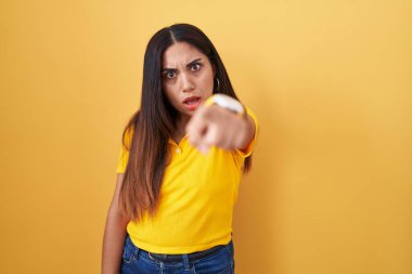 Sarı arka planda dikilen genç Arap kadın kameraya kızgın ve sinirli olduğunu gösteriyor. 