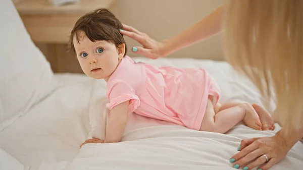 Mother and daughter crawling on bed at bedroom