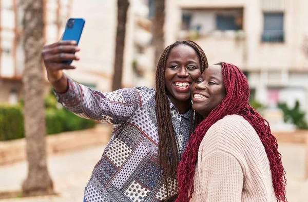 自信を持って笑顔アフリカ系アメリカ人女性の友人作ります自画自画自賛公園でスマートフォン — ストック写真
