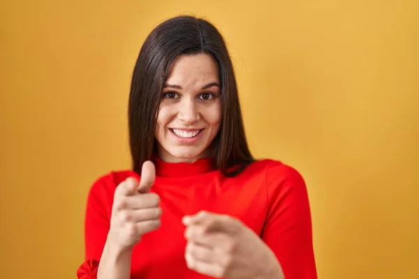 若いヒスパニック系の女性が幸せと面白い顔でカメラに指を指して黄色の背景に立っている 良いエネルギーと振動は — ストック写真
