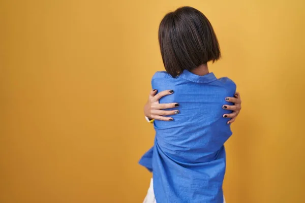 Young Girl Standing Yellow Background Hugging Oneself Happy Positive Backwards — Stock Photo, Image