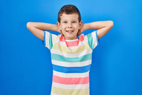 青の背景の上に立っている若い白人の子供リラックスしてストレッチ 腕と手頭と首の後ろに笑顔幸せ — ストック写真