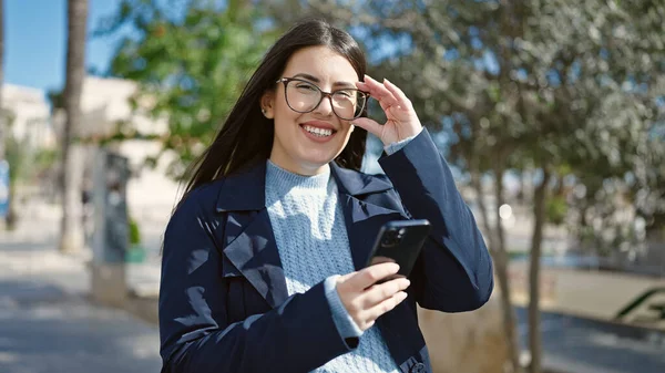 Joven Mujer Hispana Sonriendo Confiada Usando Smartphone Parque —  Fotos de Stock