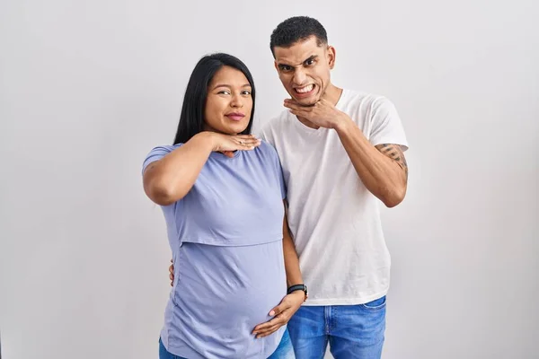 Jovem Casal Hispânico Esperando Bebê Sobre Fundo Cortando Garganta Com — Fotografia de Stock