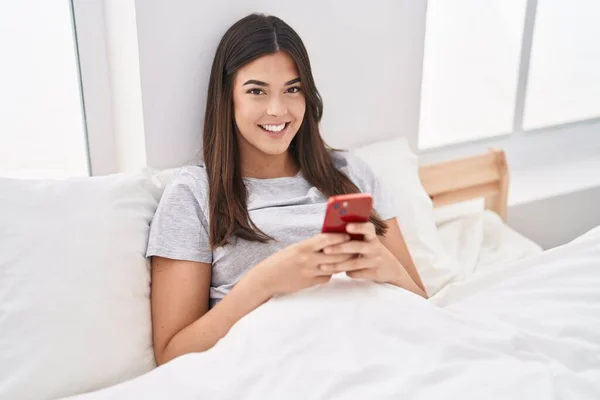 Молода Красива Іспаномовна Жінка Використовуючи Смартфон Сидячи Ліжку Спальні — стокове фото