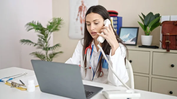 Молода Красива Іспаномовна Жінка Лікар Використовуючи Ноутбук Розмовляє Телефону Клініці — стокове фото