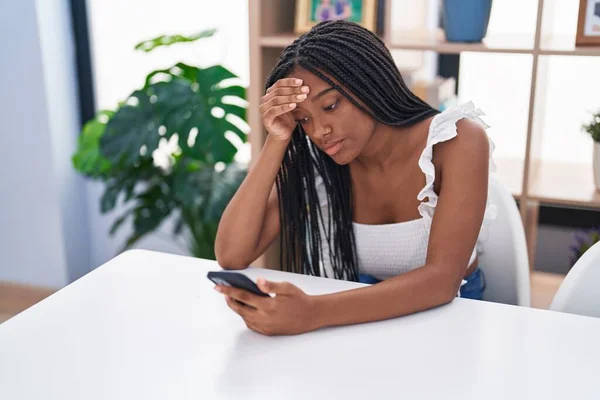 African American Woman Using Smartphone Worried Expression Home —  Fotos de Stock