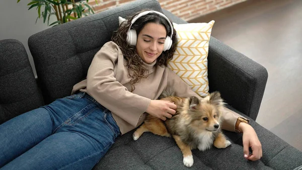 Молода Іспаномовна Жінка Собакою Слухає Музику Лежить Дивані Вдома — стокове фото
