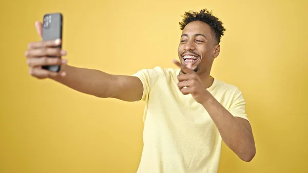 アフリカ系アメリカ人の男は自信を持って笑ってビデオ通話を持っている孤立した黄色の背景 — ストック写真