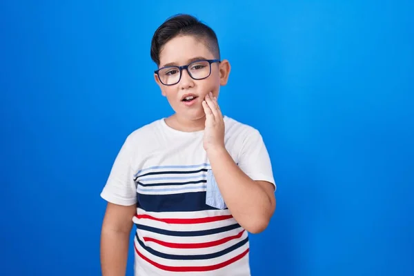 Young Hispanic Kid Standing Blue Background Touching Mouth Hand Painful — Stock Photo, Image