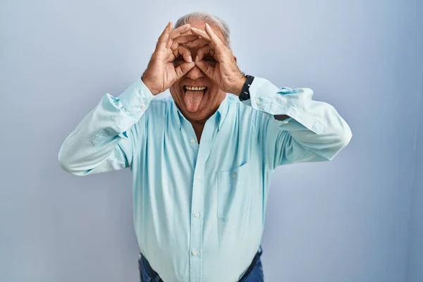 Starší Muž Šedivými Vlasy Stojící Nad Modrým Pozadím Dělá Pořádku — Stock fotografie