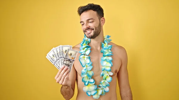 年轻的他的惊慌失措的游客穿着夏威夷莱雅的衣服 站在孤零零的黄色背景上 赤身裸体地拿着美元 — 图库照片