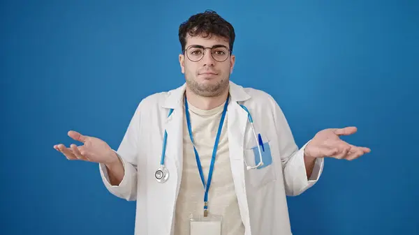 Νεαρός Ισπανός Γιατρός Που Στέκεται Ανίδεος Πάνω Από Απομονωμένο Μπλε — Φωτογραφία Αρχείου