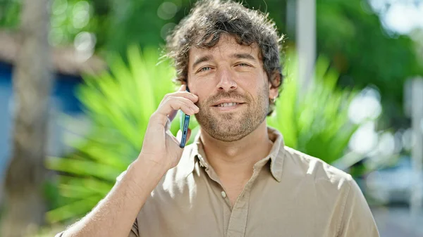 Joven Hombre Hispano Sonriendo Confiado Hablando Smartphone Parque —  Fotos de Stock