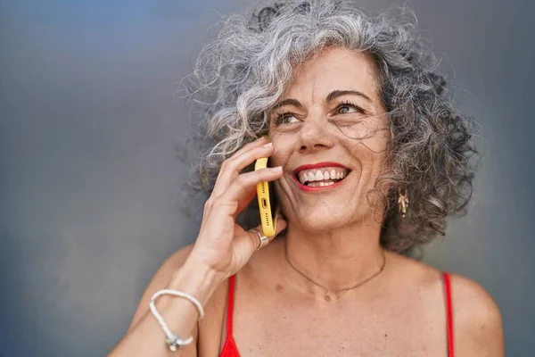 Mujer Pelo Gris Mediana Edad Sonriendo Confiada Hablando Teléfono Inteligente —  Fotos de Stock