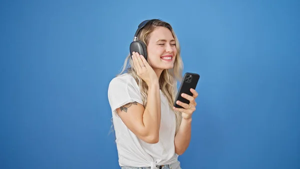 Jonge Blonde Vrouw Luisteren Naar Muziek Dansen Geïsoleerde Blauwe Achtergrond — Stockfoto