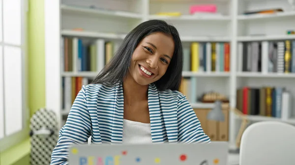 図書館大学でノートパソコンを使うアフリカ系アメリカ人女性学生 — ストック写真