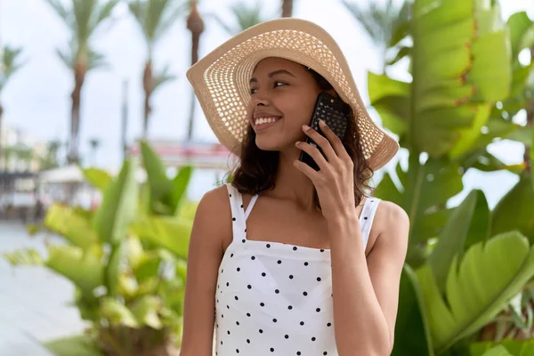 stock image Young african american woman wearing summer hat talking on smartphone at park