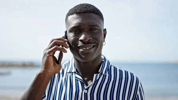 Африканский Американец Улыбается Уверенно Разговаривая Смартфону Пляже — стоковое фото