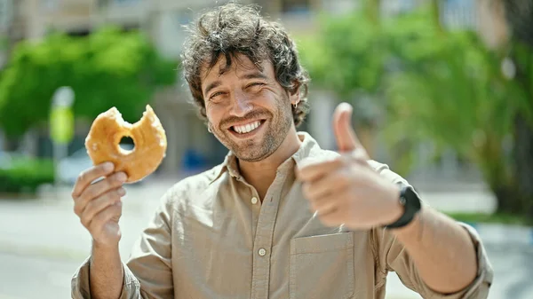 Jovem Hispânico Homem Segurando Donut Fazendo Polegar Até Gesto Rua — Fotografia de Stock