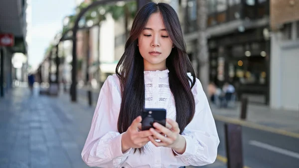 Young Chinese Woman Using Smartphone Serious Expression Street — Stockfoto