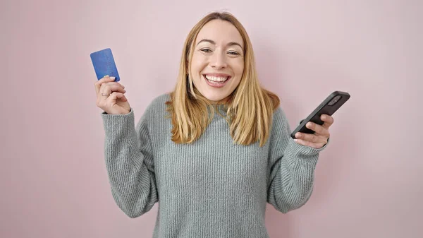 Młoda Blondynka Zakupy Smartfonem Kartą Kredytową Wyrazem Zwycięzcy Odizolowanym Różowym — Zdjęcie stockowe