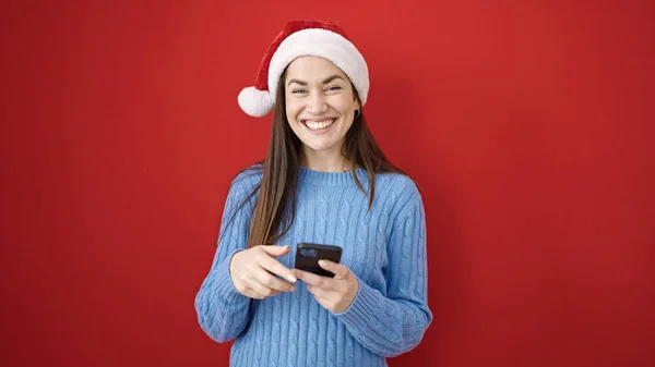 Νεαρή Καυκάσια Γυναίκα Φοράει Χριστουγεννιάτικο Καπέλο Χρησιμοποιώντας Smartphone Πάνω Από — Φωτογραφία Αρχείου