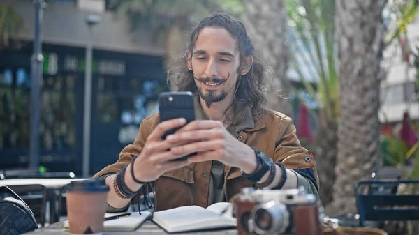 年轻的他的惊慌失措的游客坐在咖啡店阳台的桌子上 用智能手机 — 图库照片