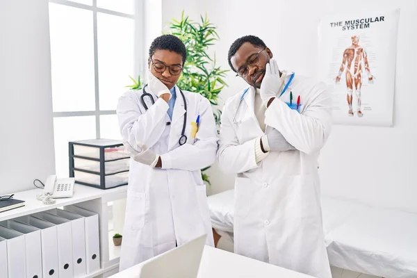 在诊所工作的年轻的非洲裔美国医生认为 他们看起来疲惫不堪 对交叉双臂的抑郁症感到厌烦 — 图库照片