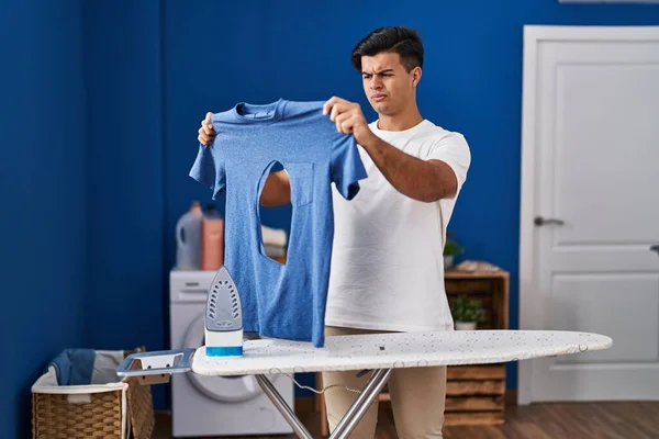 Hombre Hispano Planchando Sosteniendo Camisa Hierro Quemada Lavandería Escéptico Nervioso —  Fotos de Stock