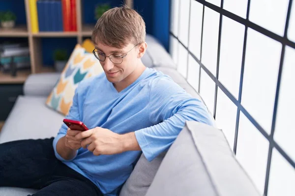 Young Caucasian Man Using Smartphone Sitting Sofa Home — Fotografia de Stock