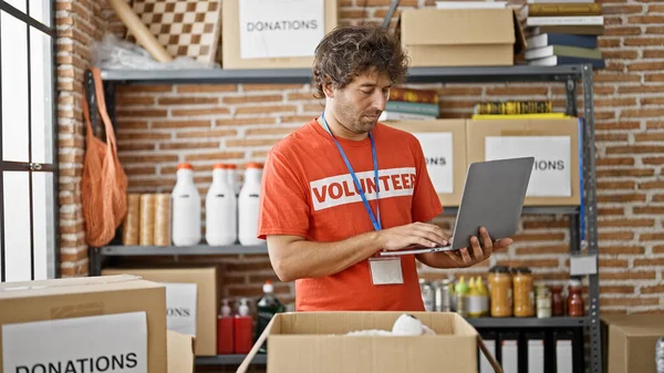 Joven Hispano Voluntario Usando Portátil Comprobando Productos Centro Caridad — Foto de Stock