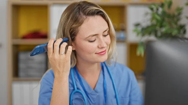 Joven Doctora Rubia Usando Computadora Escuchando Mensaje Voz Por Teléfono —  Fotos de Stock