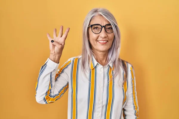 Sarı Arka Planda Duran Gri Saçlı Orta Yaşlı Kadın Gözlük — Stok fotoğraf