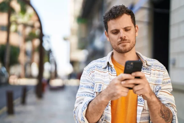 Joven Hispano Usando Smartphone Calle —  Fotos de Stock
