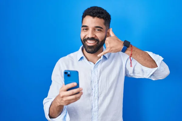 Hombre Hispano Con Barba Usando Teléfono Inteligente Escribiendo Mensaje Sonriendo —  Fotos de Stock