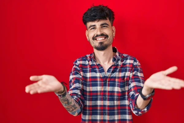 Jovem Hispânico Com Barba Sobre Fundo Vermelho Sorrindo Alegre Oferecendo — Fotografia de Stock