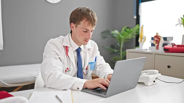 Klinikte Çalışan Genç Beyaz Bir Doktor Dizüstü Bilgisayar Kullanıyor — Stok fotoğraf