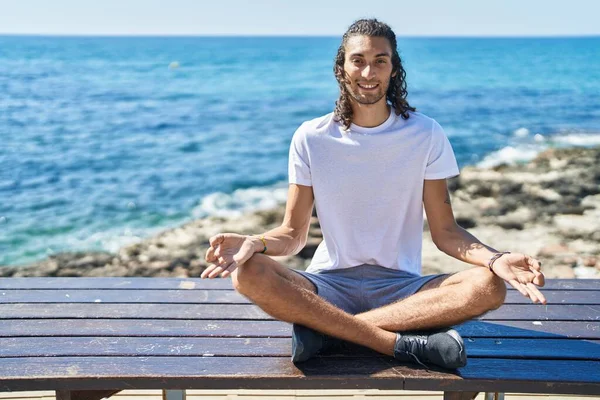 Young Hispanic Man Doing Yoga Exercise Sitting Bench Seaside —  Fotos de Stock