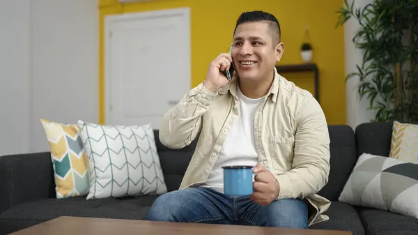 Młody Hiszpan Rozmawiający Przez Telefon Pijący Kawę Domu — Zdjęcie stockowe