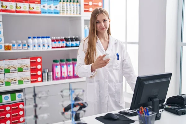 Joven Mujer Caucásica Farmacéutica Sosteniendo Pastillas Botella Utilizando Computadora Farmacia —  Fotos de Stock