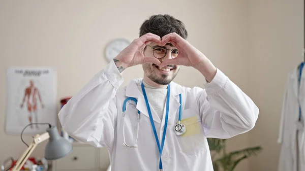 Νεαρός Ισπανός Γιατρός Χαμογελάει Κάνοντας Χειρονομία Καρδιάς Χέρια Στην Κλινική — Φωτογραφία Αρχείου