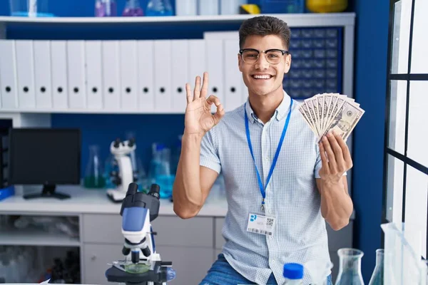Jeune Homme Hispanique Travaillant Laboratoire Scientifique Tenant Des Dollars Faisant — Photo